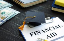 Graduation cap and financial aid for student form on the desk.